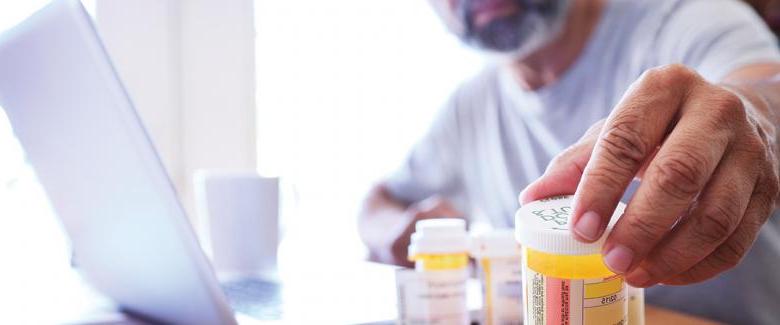 Man reaching out to prescription bottle